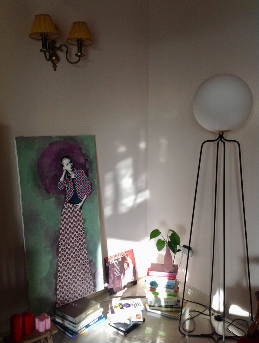a table with a sculpture on it and a painting on wall